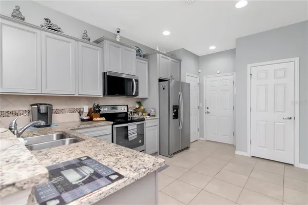 a kitchen with stainless steel appliances granite countertop a refrigerator and a sink