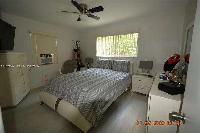 a bedroom with a bed and a flat tv screen on the dresser