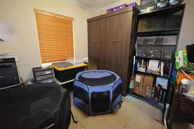 a living room with furniture a flat screen tv and a refrigerator