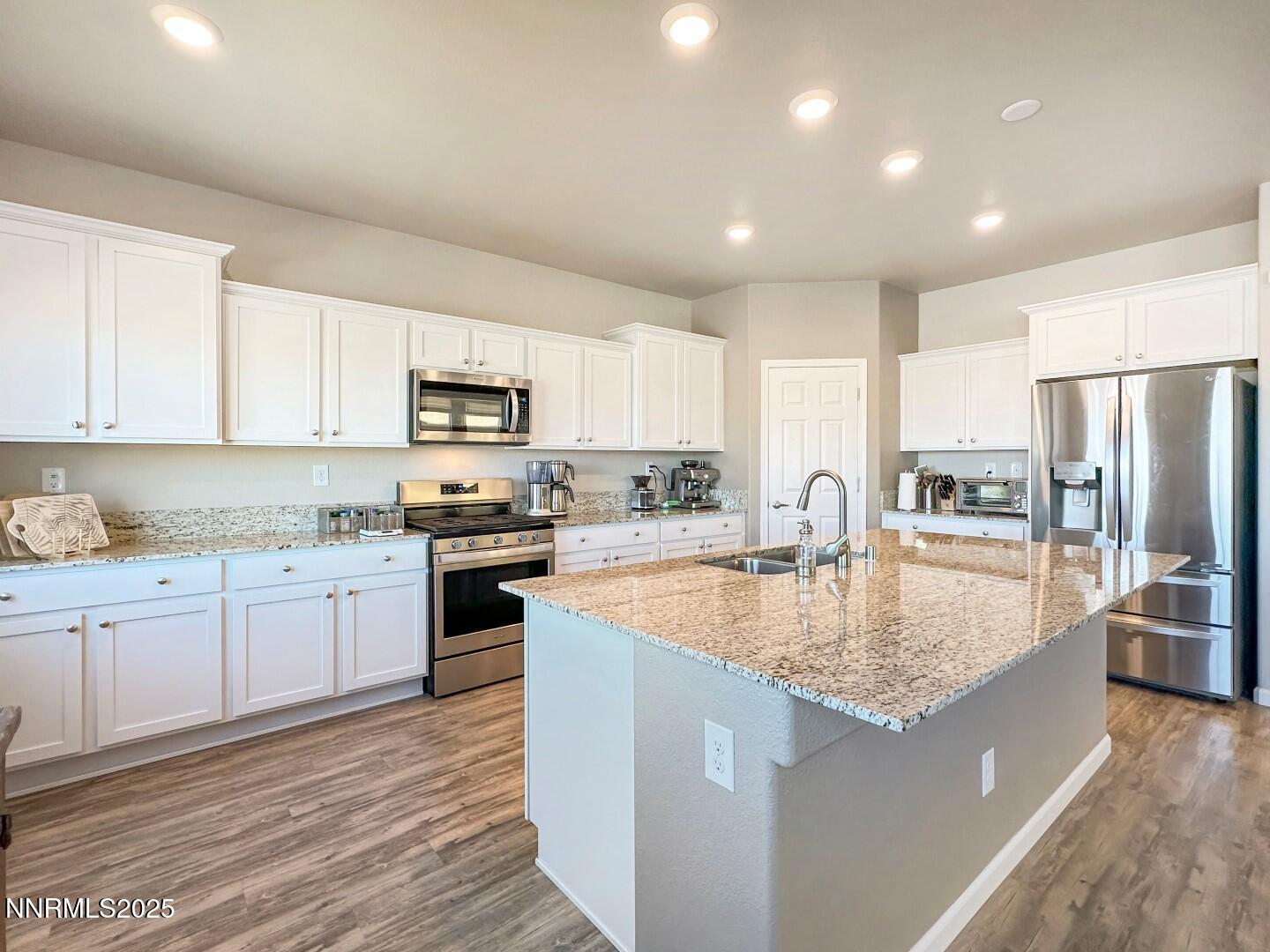 2015 Painted Sky Way Sun Valley, NV 89433 - Photo 5 of 31 a large kitchen with granite countertop a stove and a sink