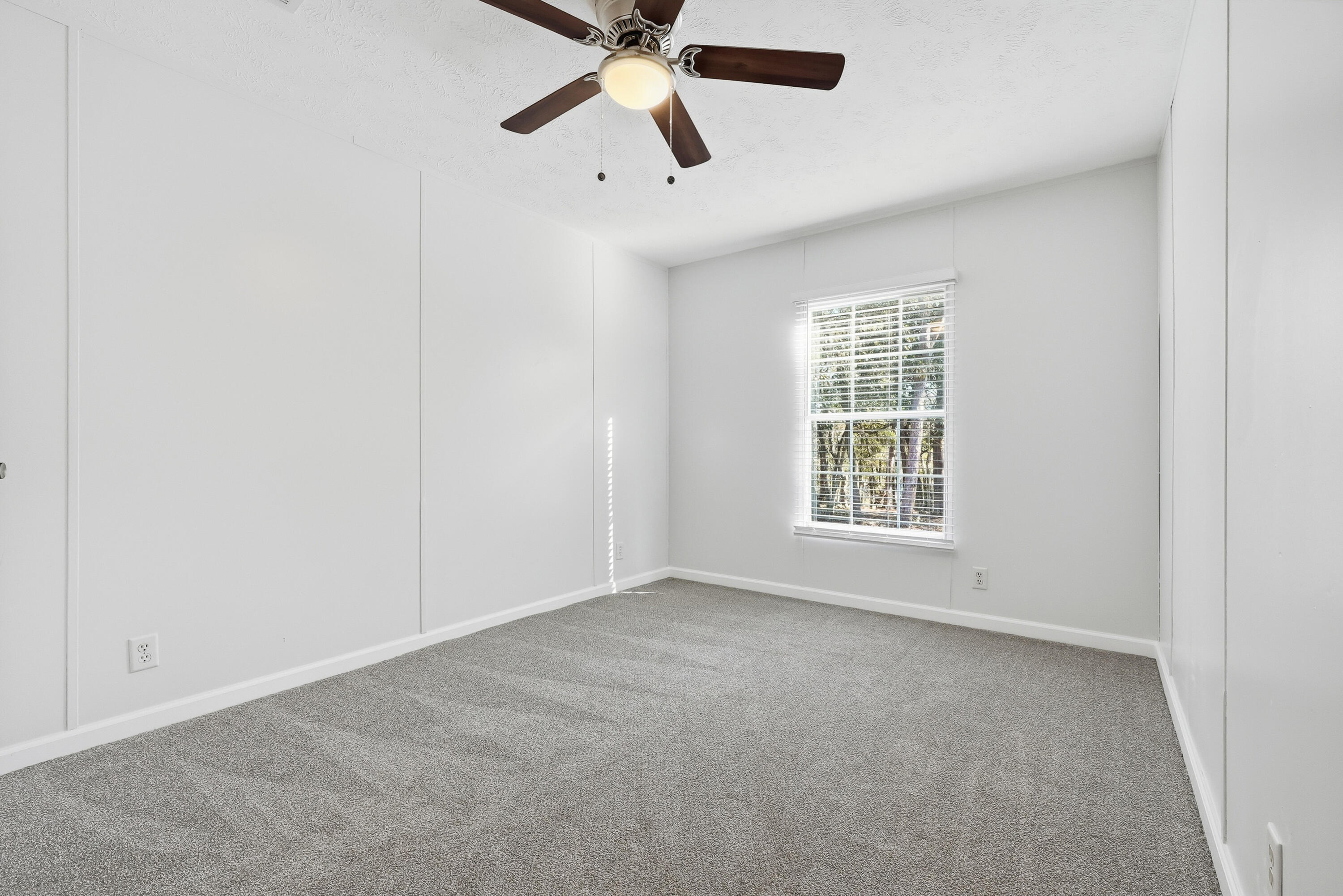 482 Roberts Road East DeFuniak Springs, FL 32433 - Photo 42 of 61 an empty room with chandelier fan and windows