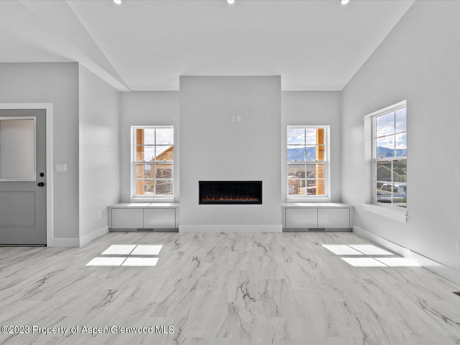 1416 Rifle Heights Drive Rifle, CO 81650 - Photo 15 of 35 an empty room with wooden floor and windows