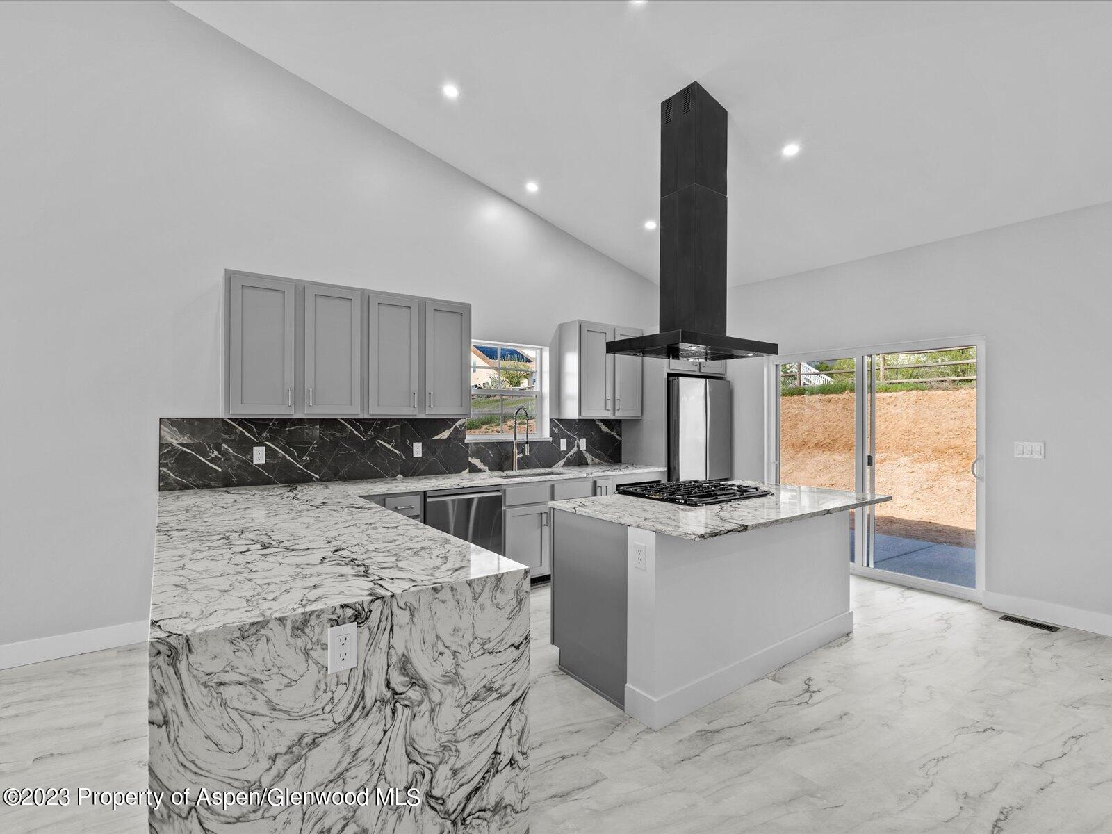 1416 Rifle Heights Drive Rifle, CO 81650 - Photo 16 of 35 a kitchen with stainless steel appliances kitchen island a stove a sink and white walls