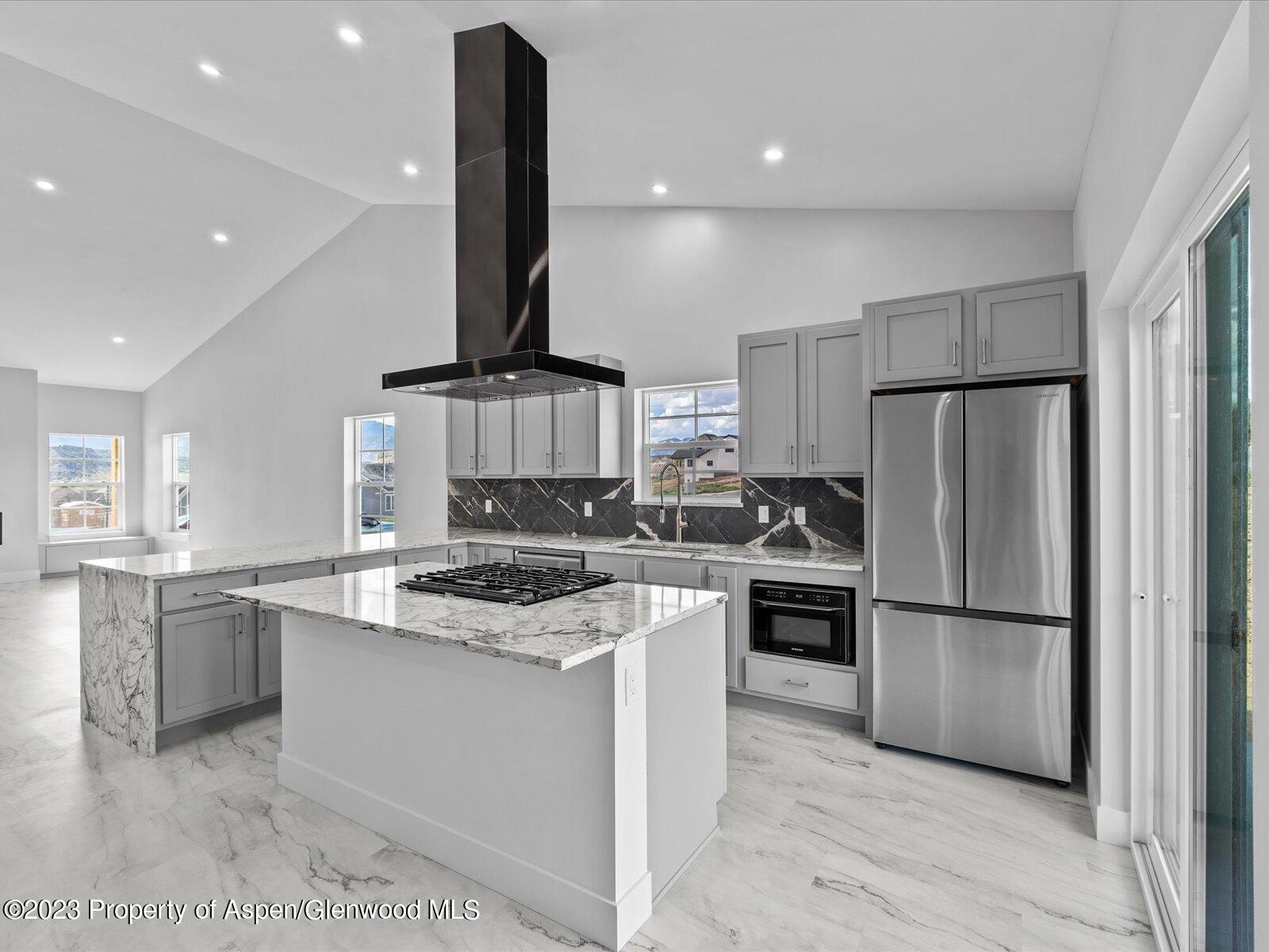 1416 Rifle Heights Drive Rifle, CO 81650 - Photo 18 of 35 a kitchen with stainless steel appliances granite countertop a refrigerator a stove a sink and a refrigerator