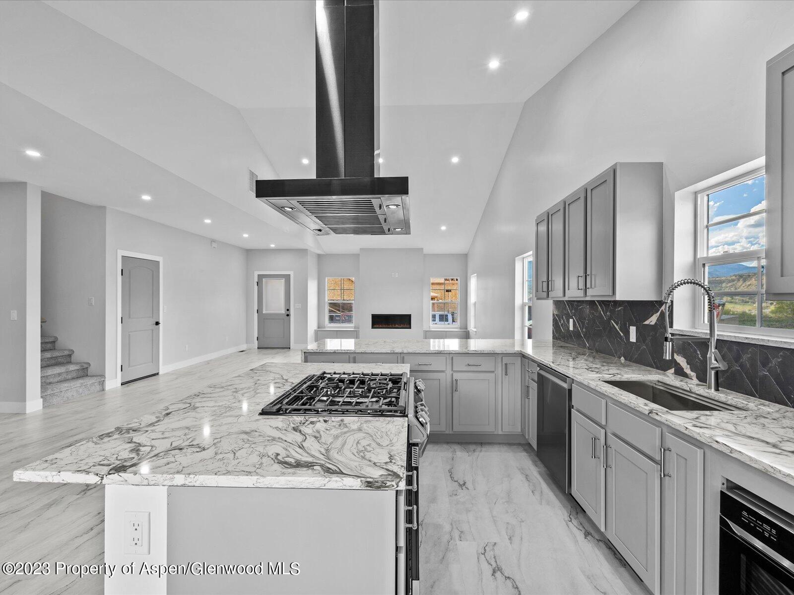 1416 Rifle Heights Drive Rifle, CO 81650 - Photo 20 of 35 a kitchen with stainless steel appliances granite countertop a sink stove and cabinets