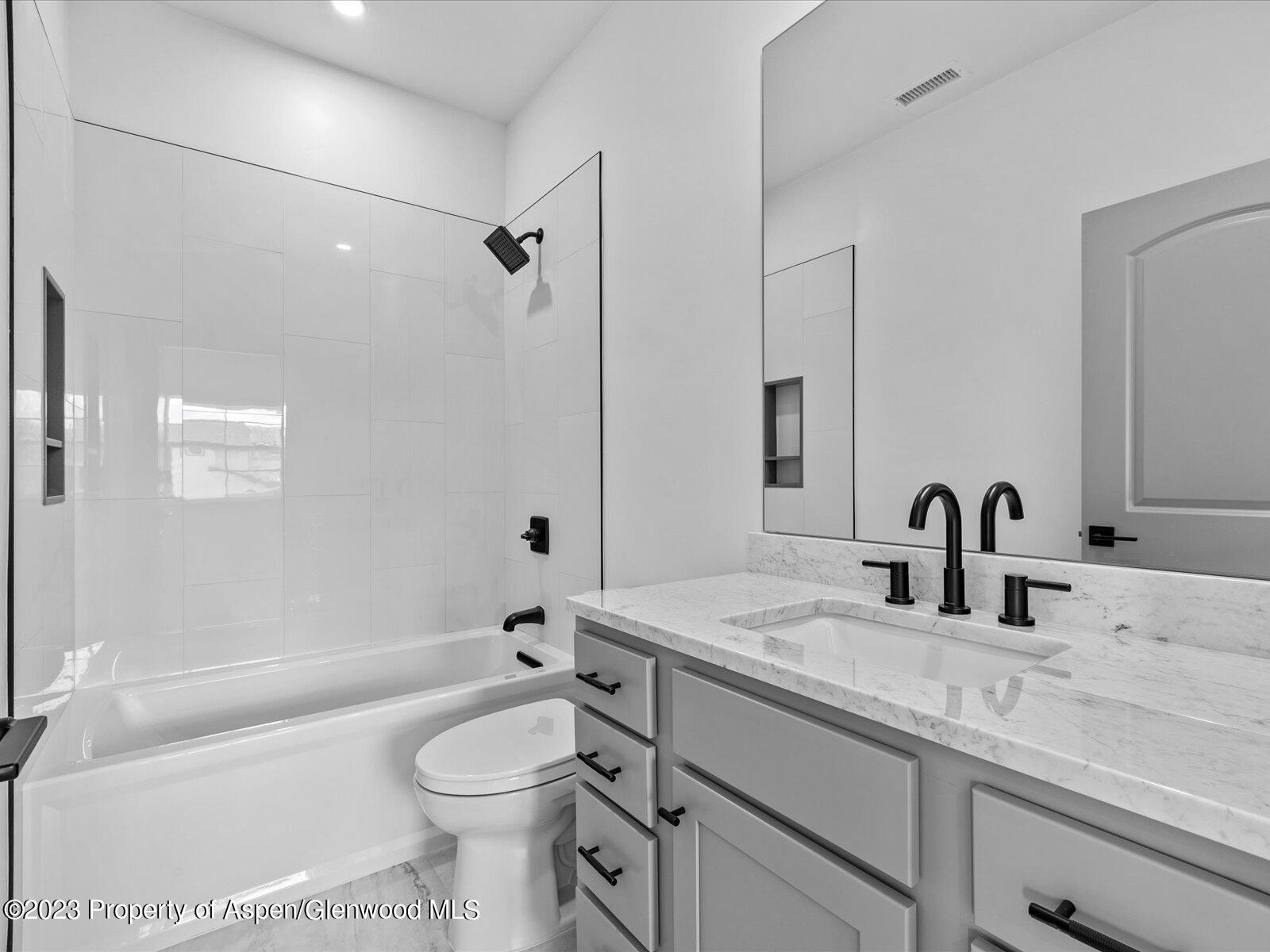 1416 Rifle Heights Drive Rifle, CO 81650 - Photo 30 of 35 a bathroom with a granite countertop toilet sink and a bathtub