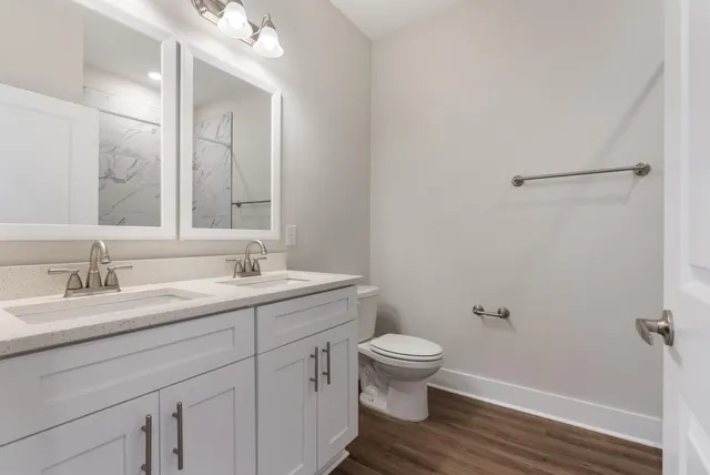 a bathroom with a granite countertop sink toilet and a mirror