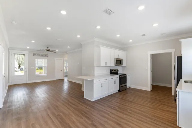 a view of kitchen with cabinets counter top space stainless steel appliances and wooden floor