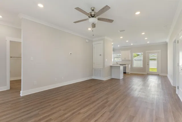 a view of an empty room with a window and wooden floor