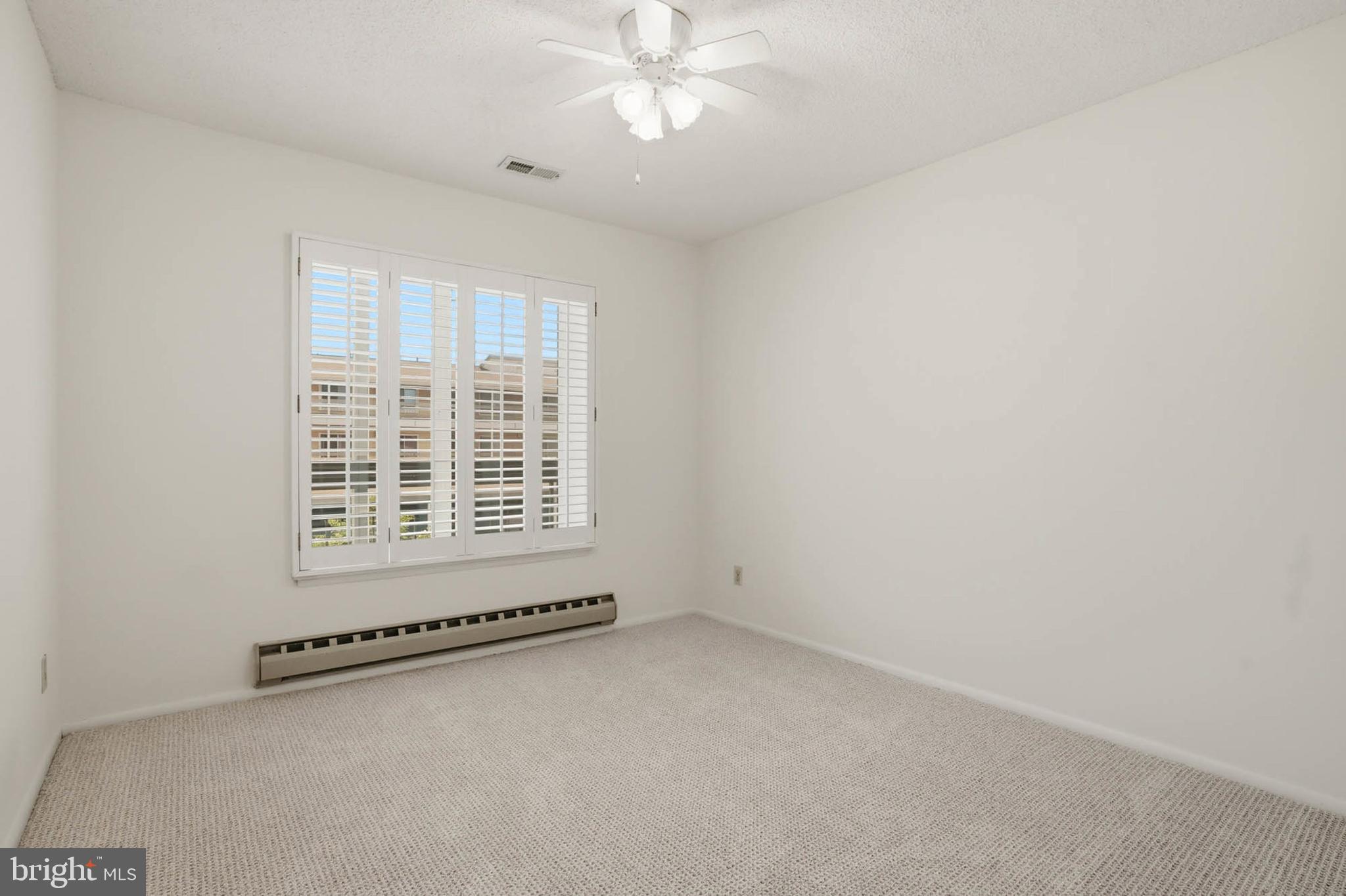 3501 Forest Edge Drive, Unit 142G Silver Spring, MD 20906 - Photo 22 of 30 an empty room with a chandelier fan and windows