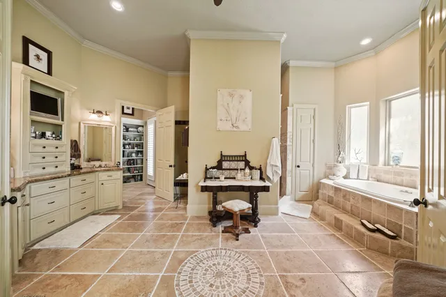 a spacious bedroom with a bed and a chandelier