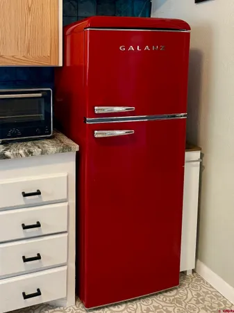 a kitchen with granite countertop a sink window and cabinets