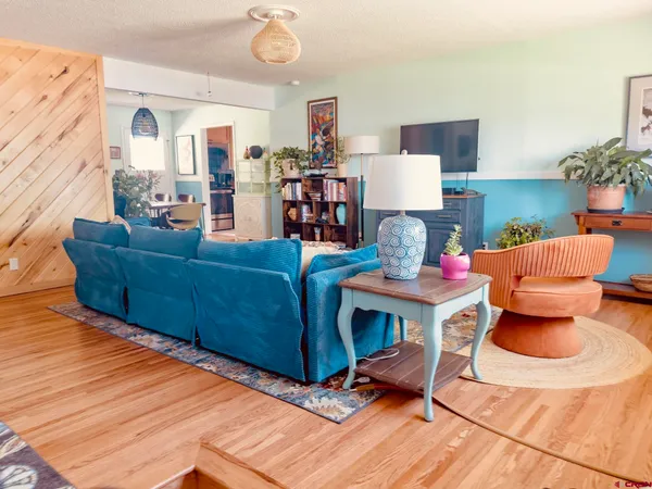 a living room with furniture and a wooden floor
