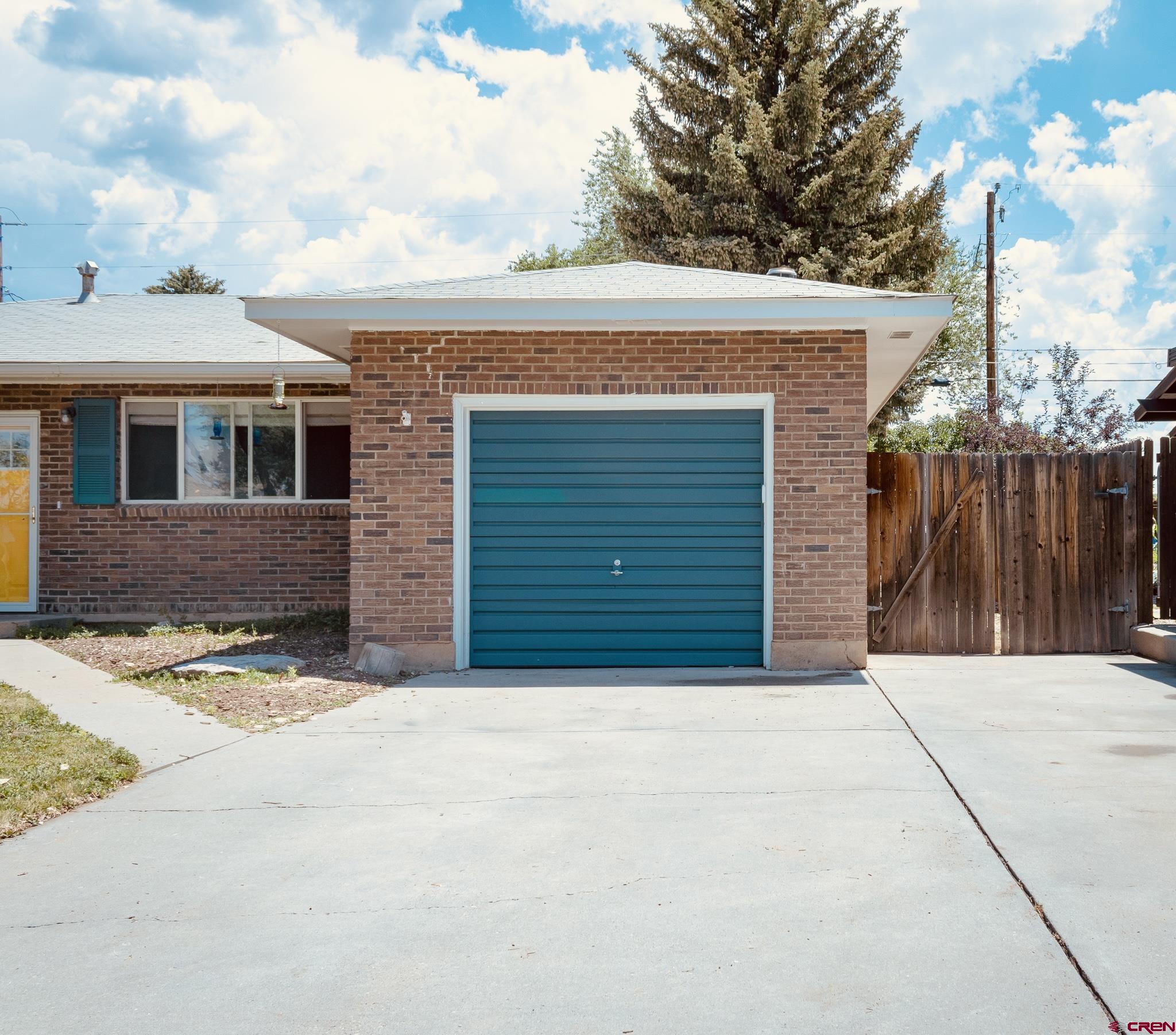 706 South Cedar Street Cortez, CO 81321 - Photo 35 of 36 a front view of a house with a yard and garage
