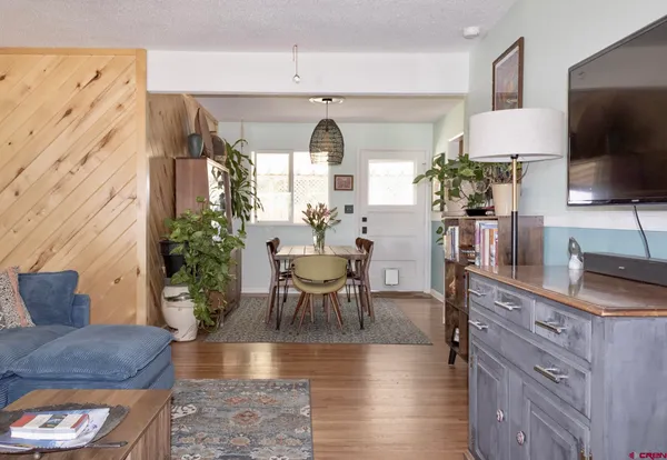 a living room with furniture a potted plant and a flat screen tv