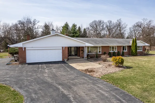 a front view of a house with a yard and trees