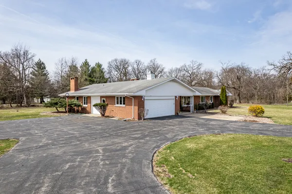 a view of a house with yard and a garden