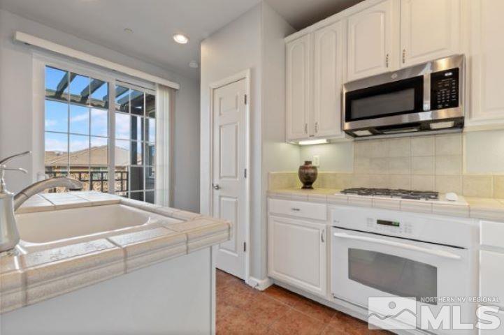 1700 Wind Ranch Road, Unit C Reno, NV 89521 - Photo 11 of 19 a kitchen with stainless steel appliances white cabinets and a granite counter tops