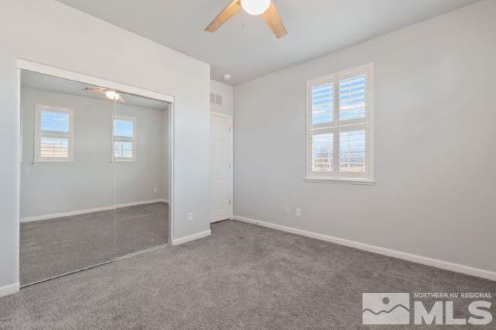 1700 Wind Ranch Road, Unit C Reno, NV 89521 - Photo 15 of 19 an empty room with windows and chandelier fan