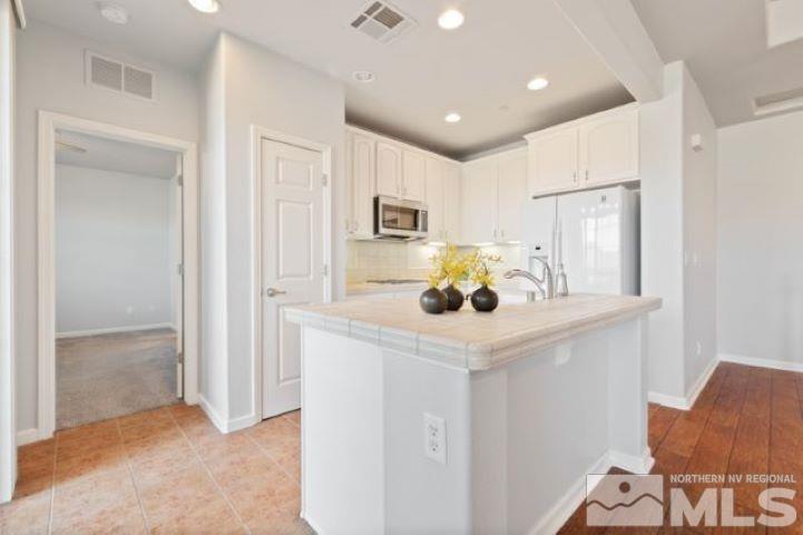 1700 Wind Ranch Road, Unit C Reno, NV 89521 - Photo 9 of 19 a kitchen with kitchen island a refrigerator stove and sink