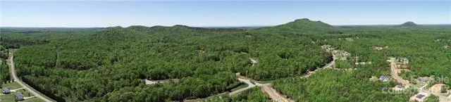 a view of a lush green field with a view of mountains in the background