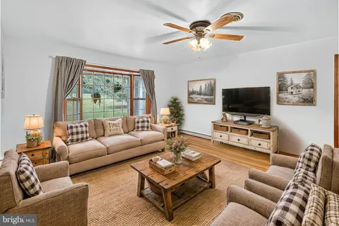 a living room with furniture a flat screen tv and a large window
