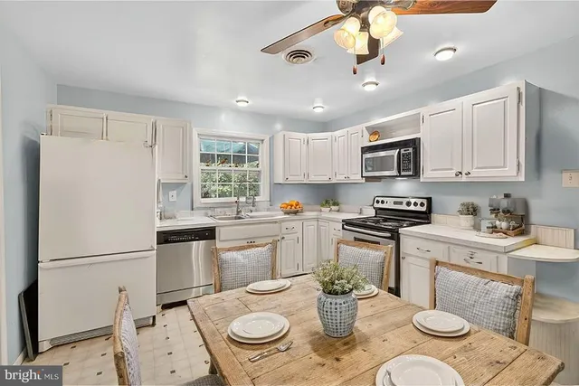 a kitchen with sink a stove a dining table and chairs