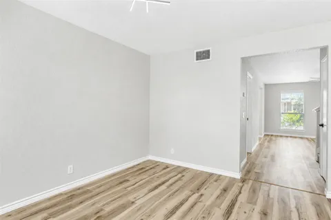 a view of a room with wooden floor and a bathroom
