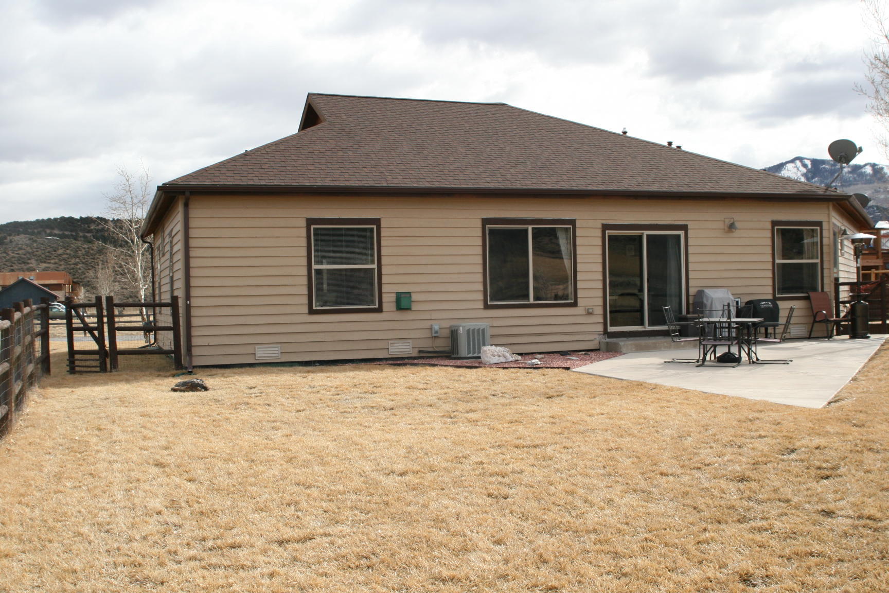 407 Kismet Street, Unit NO # Ridgway, CO 81432 - Photo 27 of 34 a backyard of a house with table and chairs under an umbrella
