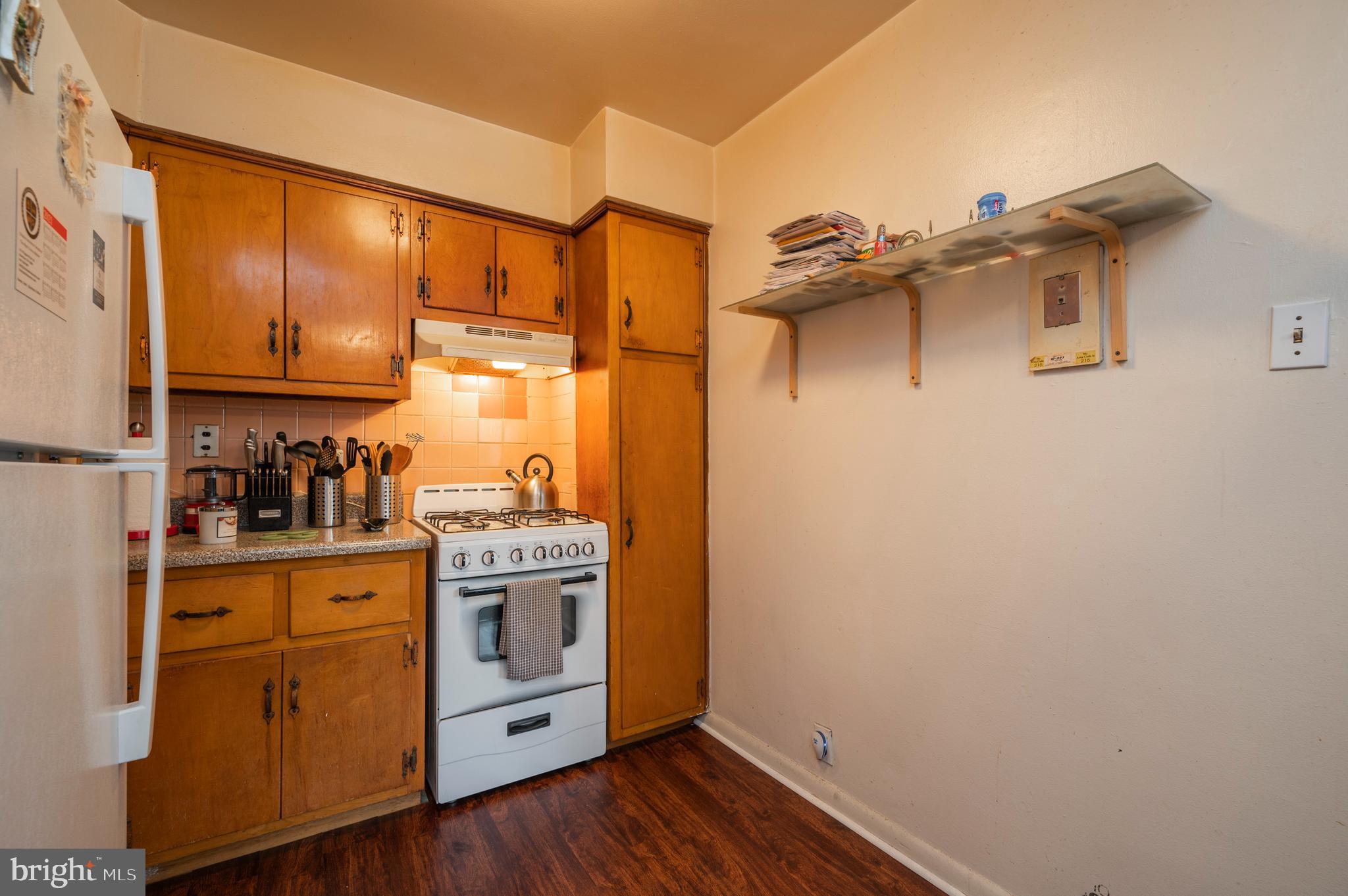 2588 Cranston Road Philadelphia, PA 19131 - Photo 9 of 38 a kitchen with a refrigerator a stove top oven and wooden floor