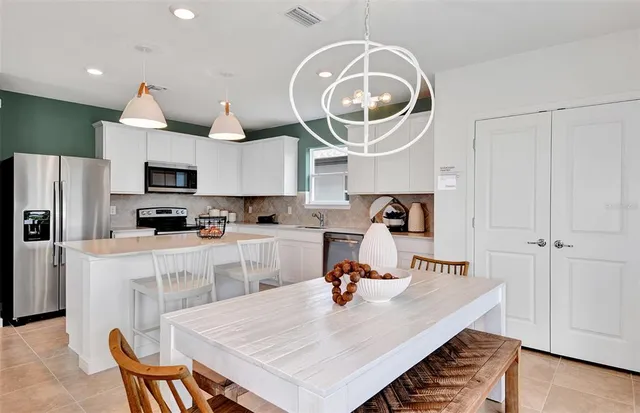 a kitchen with a table chairs and a refrigerator