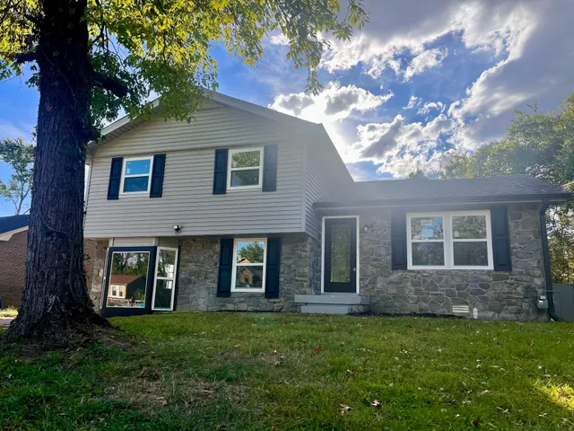 a view of a brick house with a large windows and a yard