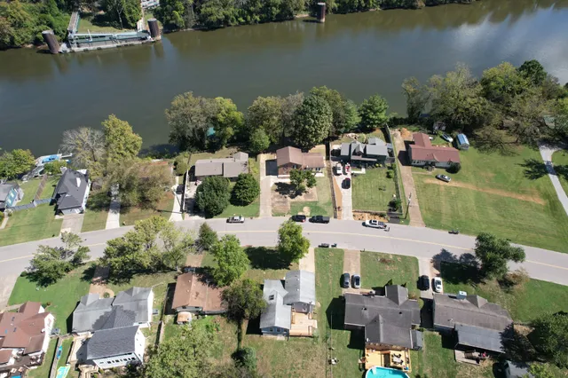 an aerial view of residential houses with outdoor space and lake view