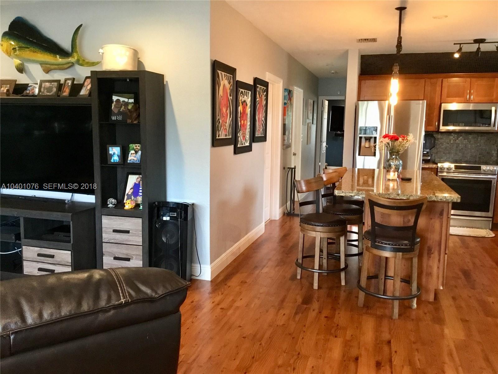 20010 Island Road Cutler Bay, FL 33189 - Photo 8 of 24 a living room with furniture a flat screen tv and kitchen view