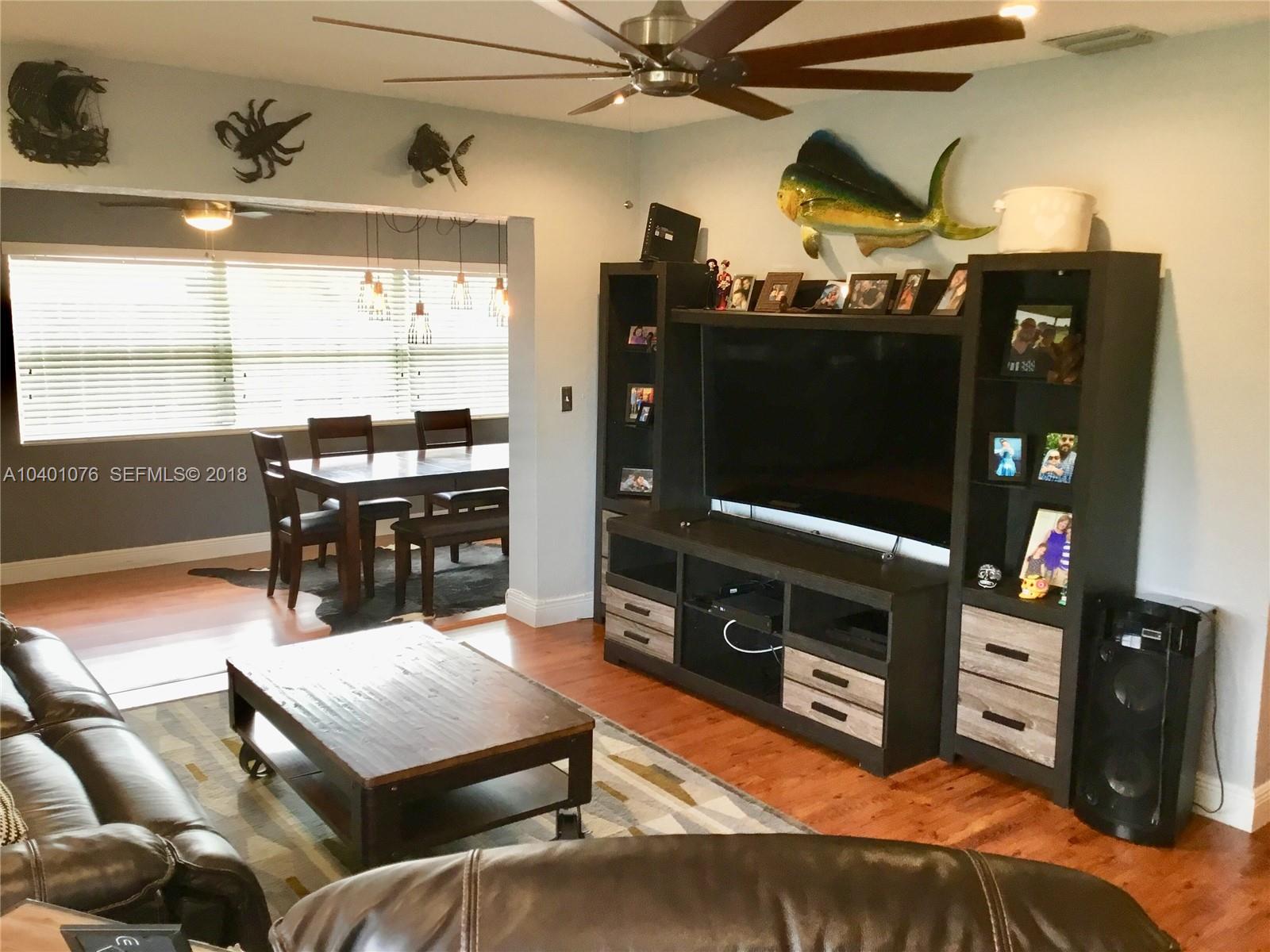 20010 Island Road Cutler Bay, FL 33189 - Photo 9 of 24 a living room with furniture a flat screen tv and kitchen view
