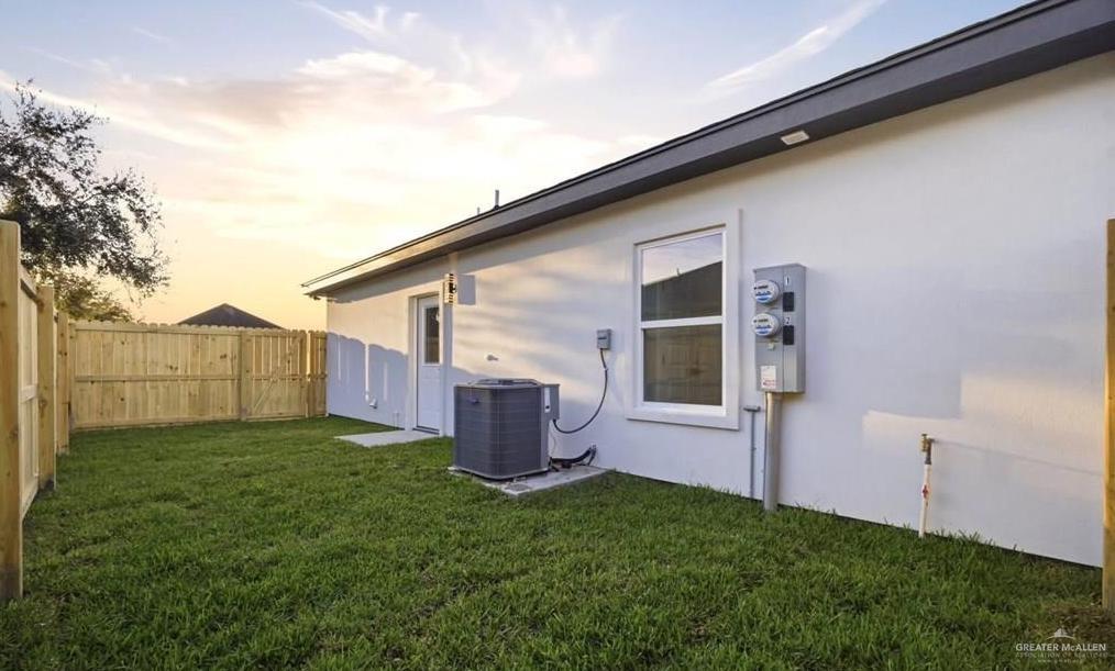 1604 Clinton Street, Unit 1 Harlingen, TX 78550 - Photo 4 of 14 Expansive backyard featuring a manicured lawn, full privacy fencing, and a concrete patio