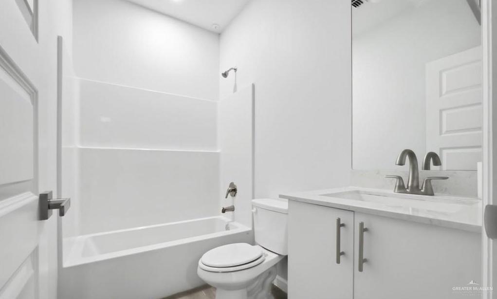 1604 Clinton Street, Unit 1 Harlingen, TX 78550 - Photo 6 of 14 Modern bathroom featuring a white vanity with a light-toned countertop, under-mount sink, and brushed nickel faucet
