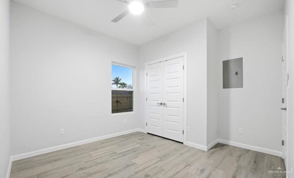 1604 Clinton Street, Unit 1 Harlingen, TX 78550 - Photo 7 of 14 Bright room featuring wood-finish flooring, a ceiling fan, and white walls