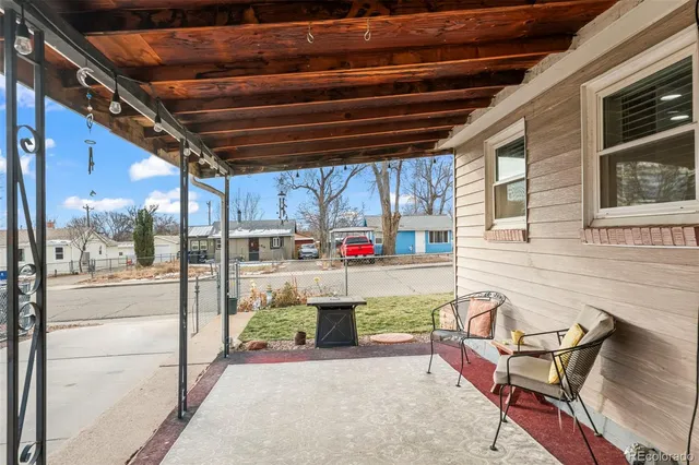 a view of a chairs and table in the back yard of the building