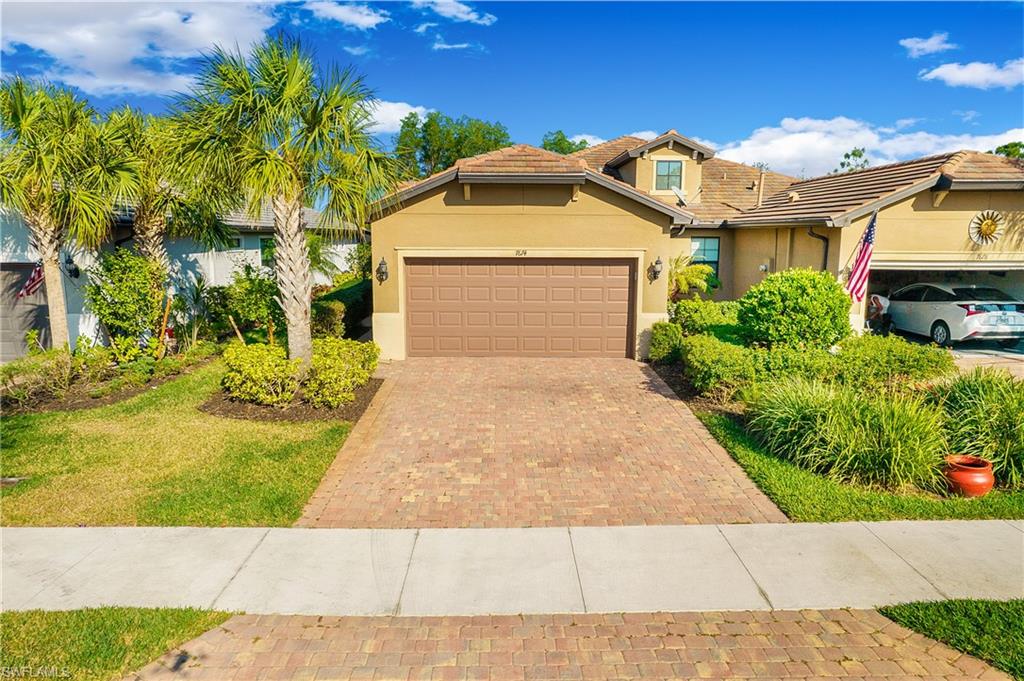7674 Jacaranda Lane Naples, FL 34114 - Photo 25 of 45 a front view of a house with a yard