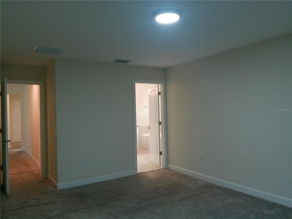 1146 Trappers Trail Loop Davenport, FL 33896 - Photo 13 of 31 an empty room with wooden floor and windows