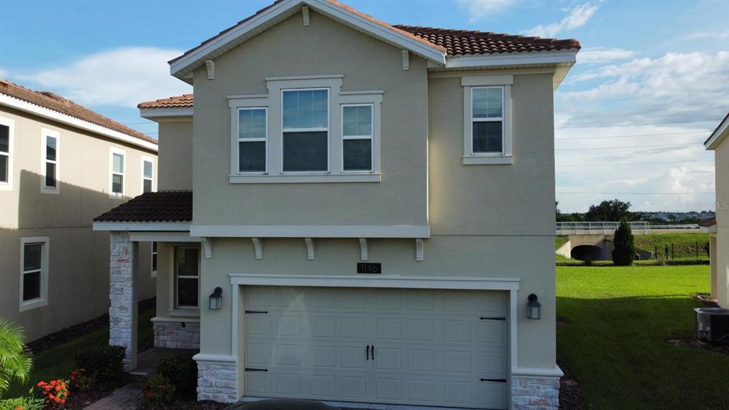 1146 Trappers Trail Loop Davenport, FL 33896 - Photo 2 of 31 a front view of a house with garden