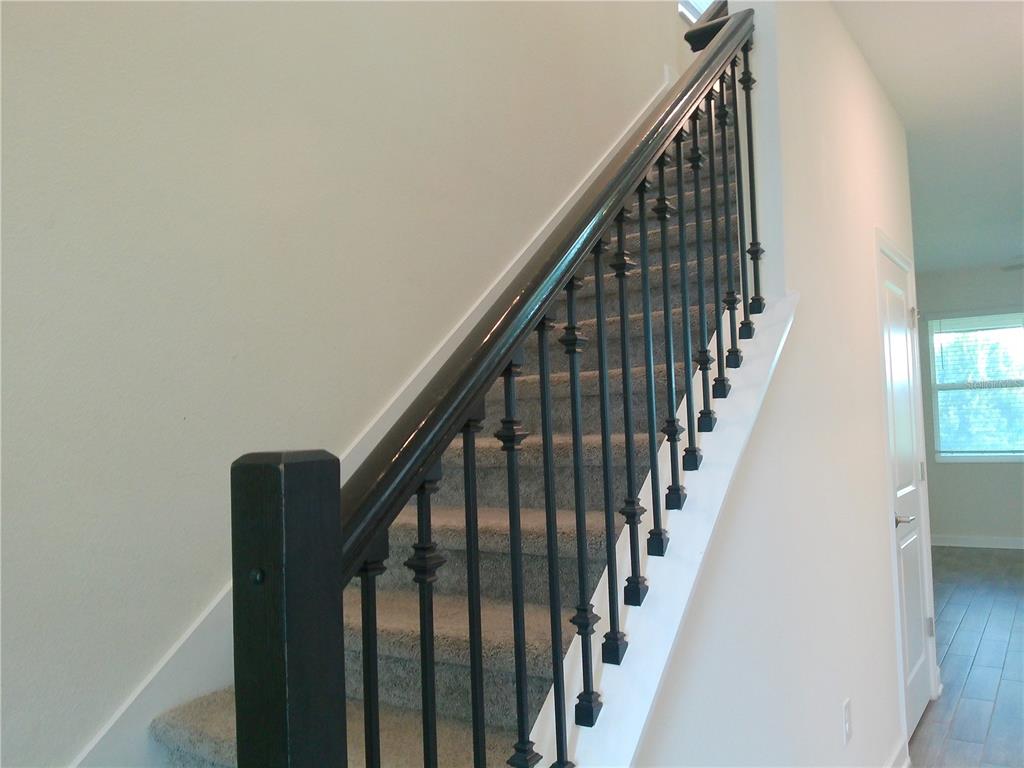 1146 Trappers Trail Loop Davenport, FL 33896 - Photo 8 of 31 a view of staircase with railing and white walls