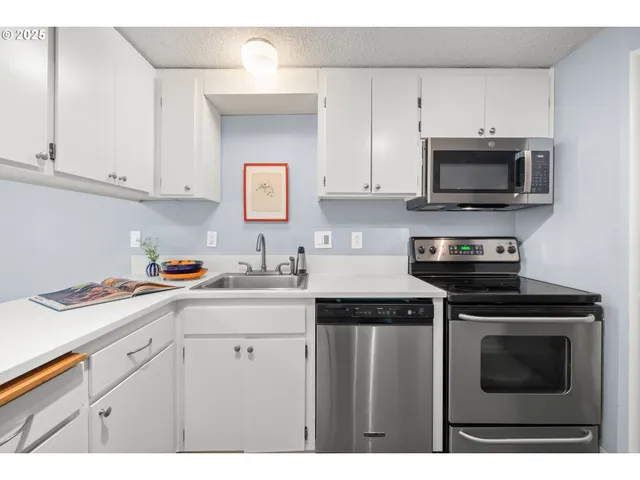 a kitchen with stainless steel appliances granite countertop a sink a stove a microwave and cabinets