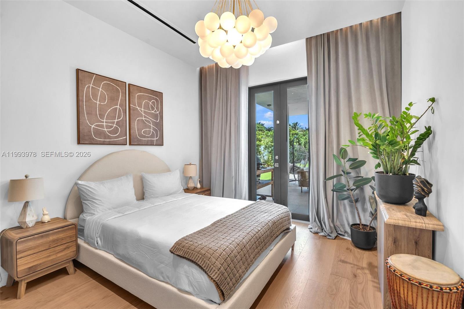 46 Northeast 162nd Street Miami, FL 33162 - Photo 41 of 44 a bedroom with a bed and a chandelier
