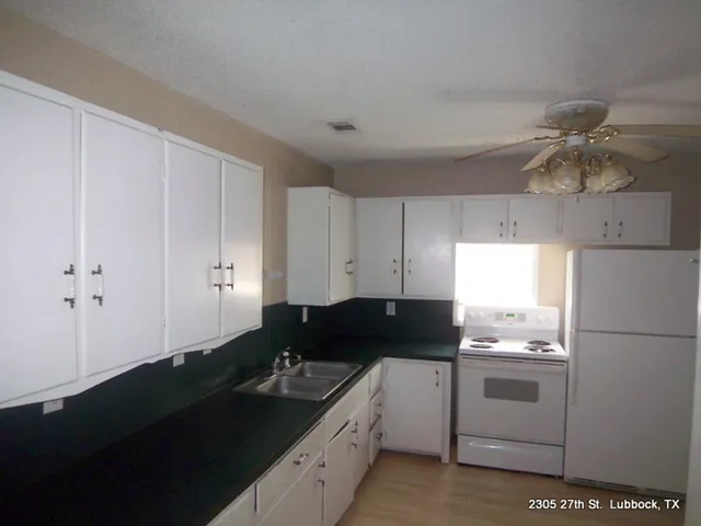a kitchen with a sink dishwasher and white cabinets