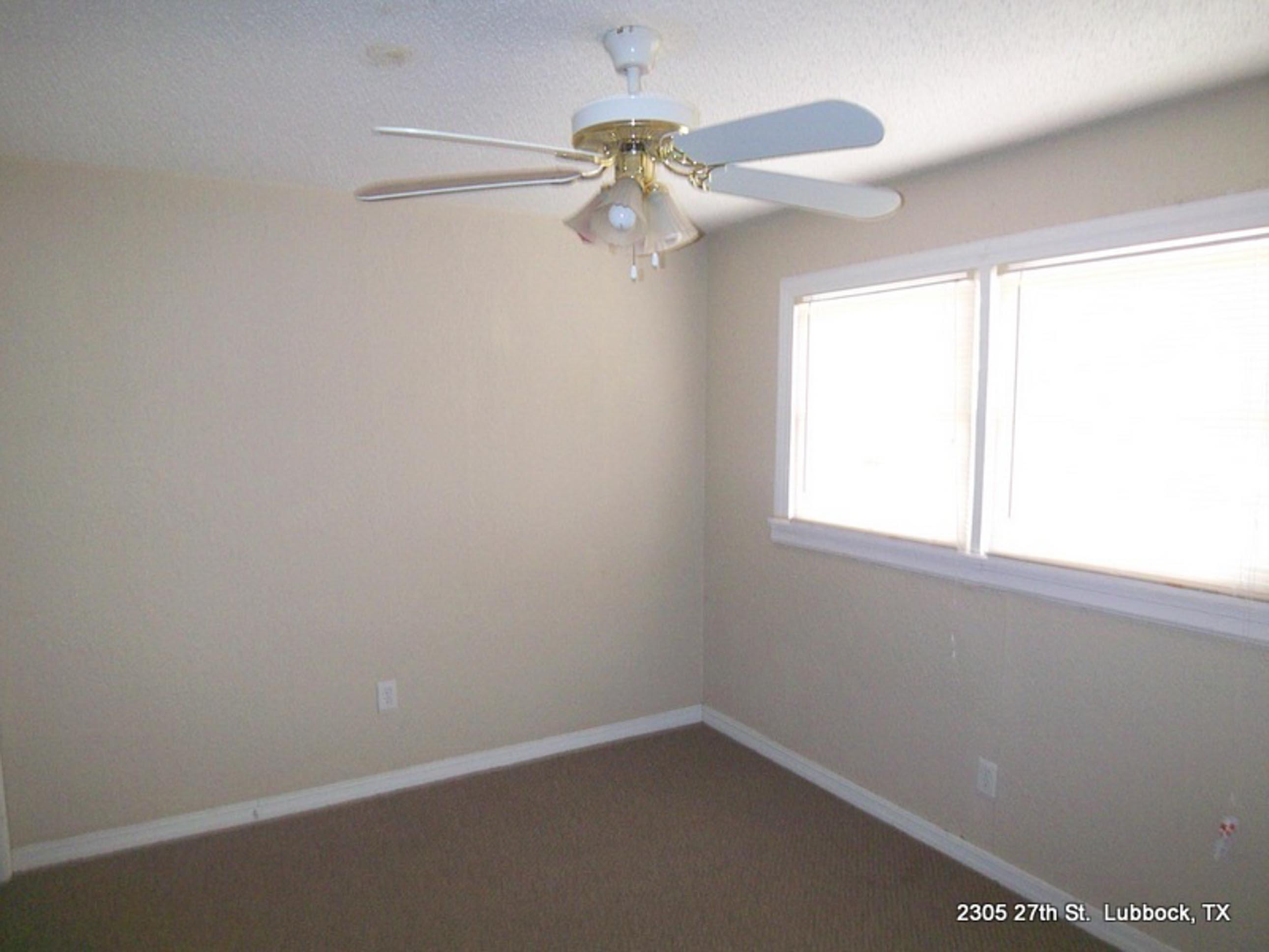 2305 27th Street, Unit FRONT Lubbock, TX 79411 - Photo 9 of 9 an empty room with a window and a fan