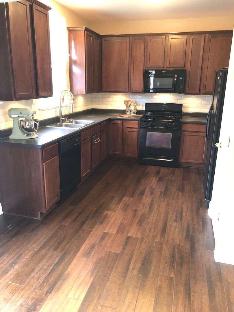 240 Copper Mountain Drive Gilberts, IL 60136 - Photo 18 of 30 a kitchen with stainless steel appliances granite countertop a sink dishwasher a stove a refrigerator with wooden cabinets and floor
