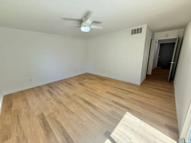 a view of empty room with wooden floor