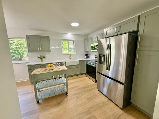 a kitchen with stainless steel appliances granite countertop a refrigerator a stove a sink and a refrigerator